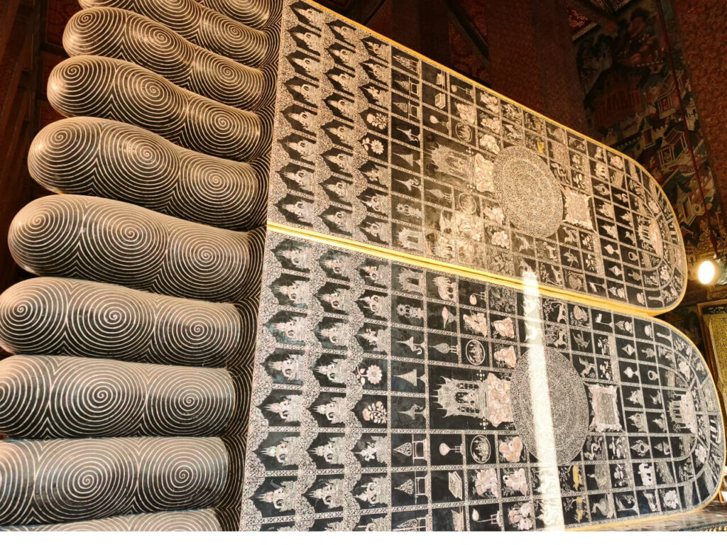 The Reclining Buddha's feet are decorated with 108 auspicious Buddhist symbols made from mother-of-pearl