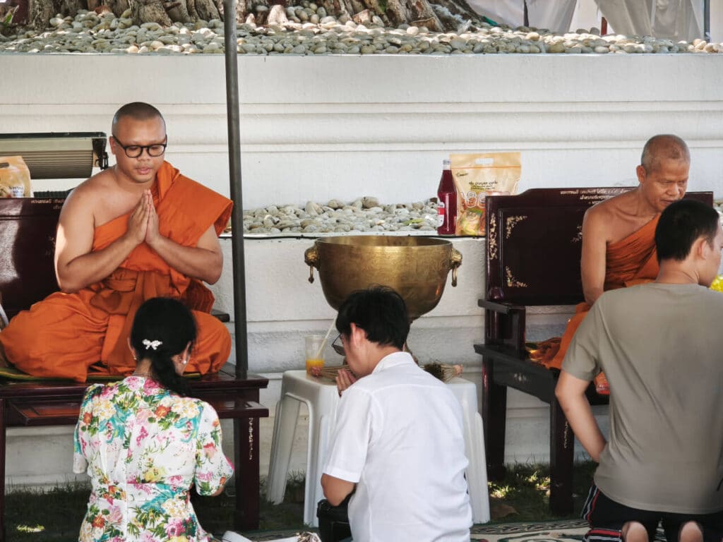 People receive blessings from a monk during Songkran