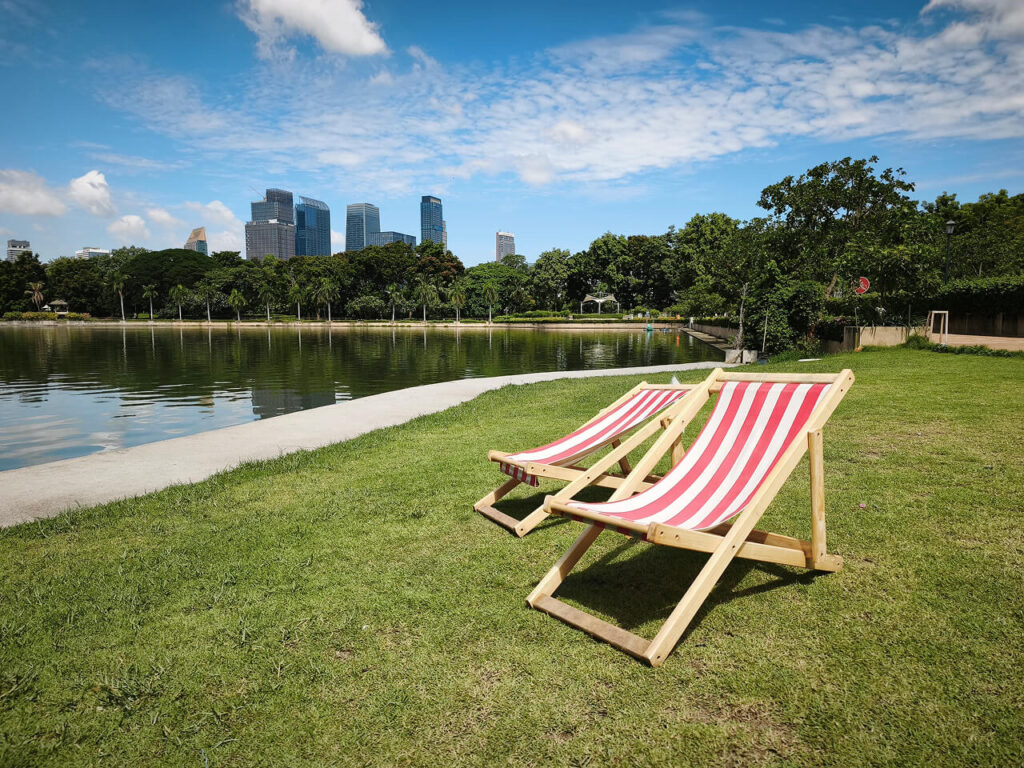 Lounge chairs by the lake at Benchakitti Park in Bangkok